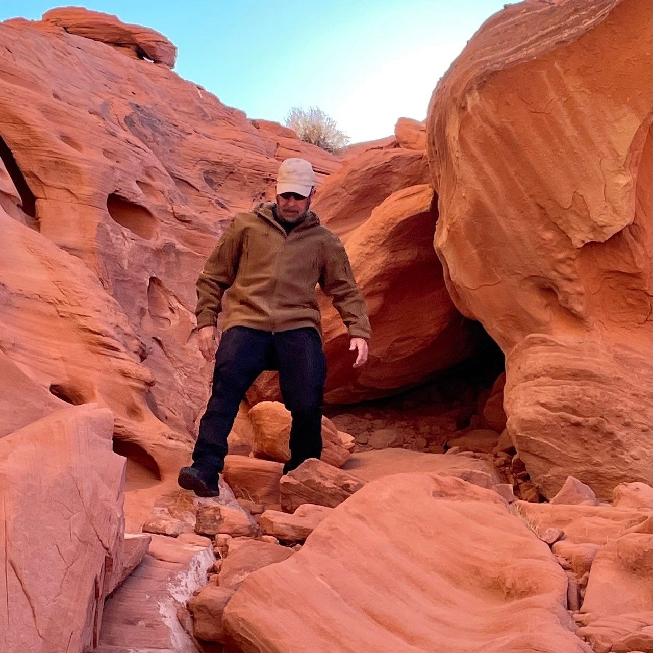 JB of The Rugged Outdoorsmen wearing an M-Tac jacket in a red rock canyon